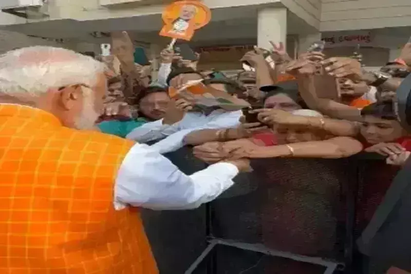 अहमदाबाद में मतदान केंद्र के बाहर भारी भीड़ के बीच बुजुर्ग महिला ने पीएम मोदी को बांधी राखी